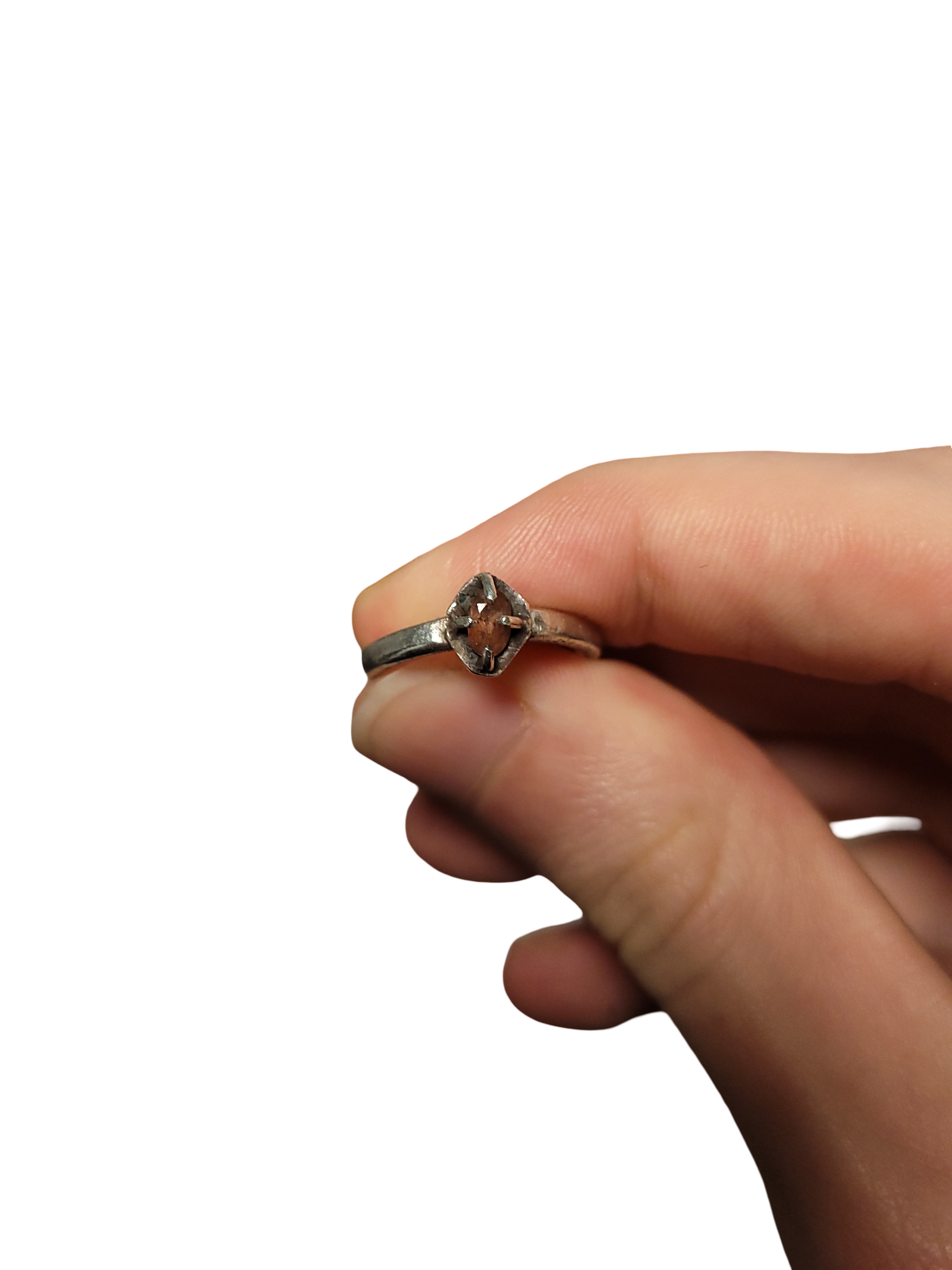 a solitare ring with tarnishing around a pink stone